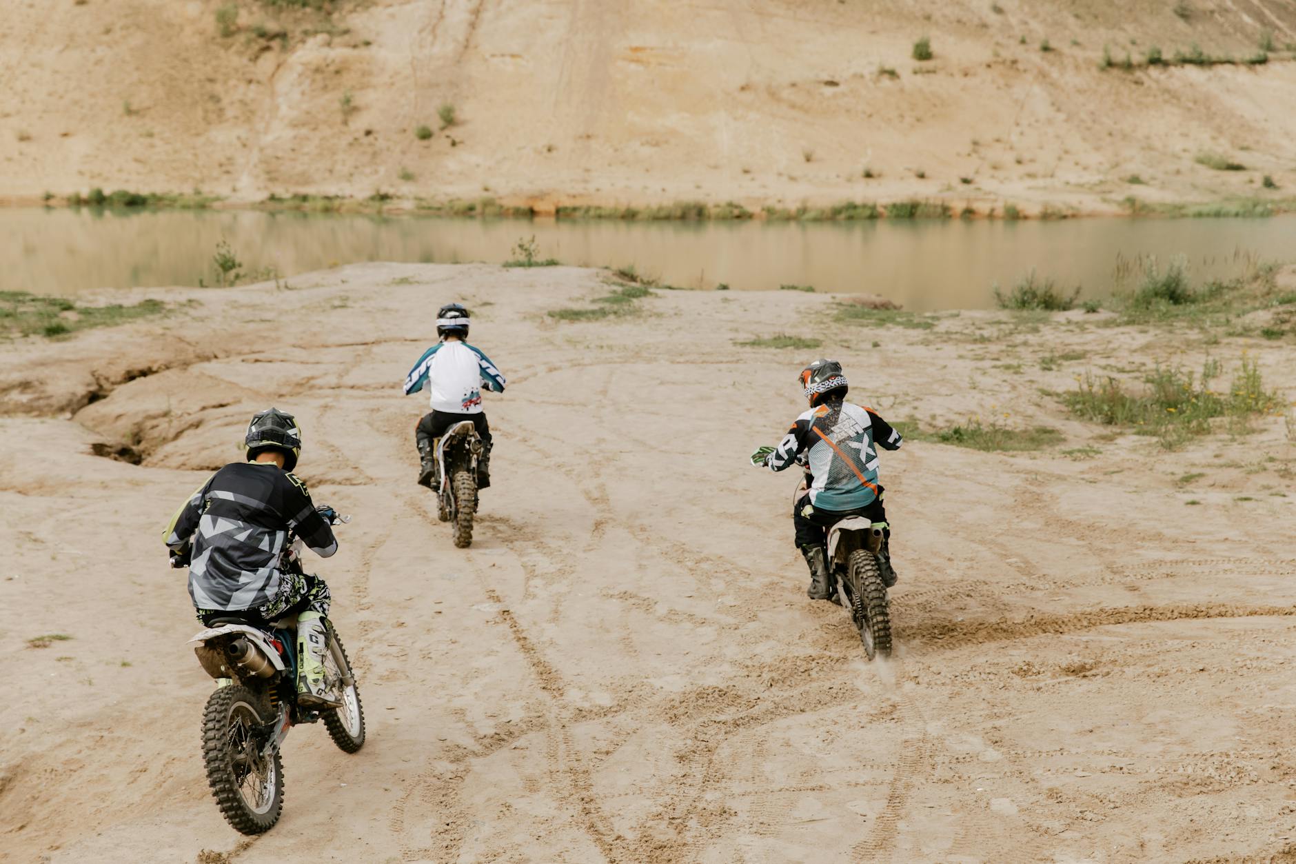 three people riding on dirt bikes